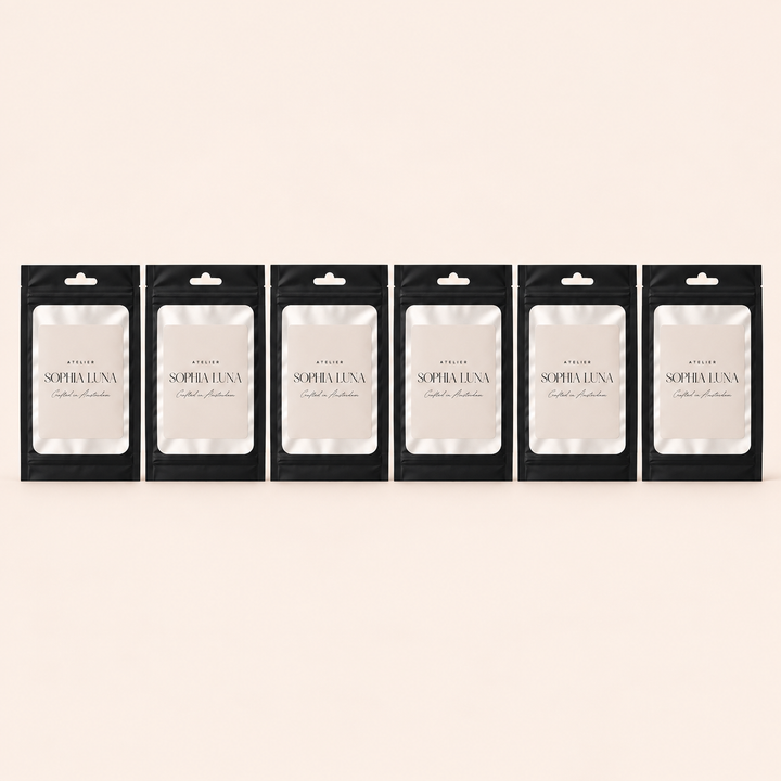 Atelier Sophia Luna geursamples in zes zwarte samplezakjes op een rij met gesloten onderkant, op een zachte blush-beige achtergrond passend bij de Aura 360 diffuser